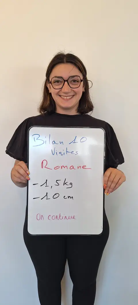 Une membre pose devant une ardoise blanche où sont notées ses mesures de bilan, au club